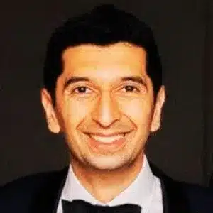 Man in suit smiling confidently on benefits of executive and business coaching services
