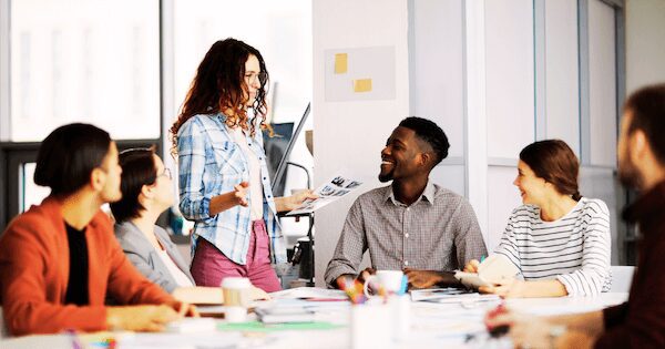 Diverse team collaborating in modern workspace, brainstorming and sharing ideas creatively.