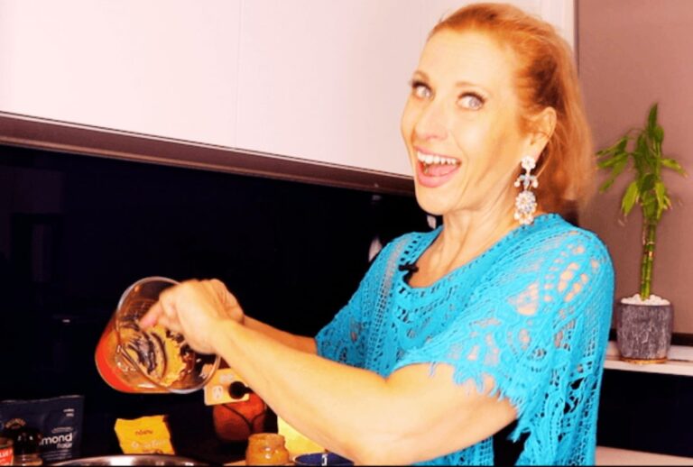 Dr. Madisen Harper cooking in vibrant kitchen, wearing turquoise lace top, making healthy recipe with joy.